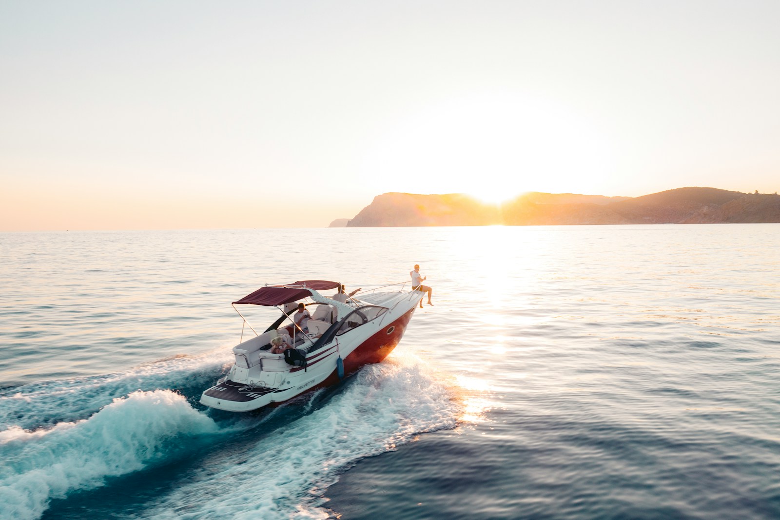 man riding on white and red boat on sea during daytime. boat