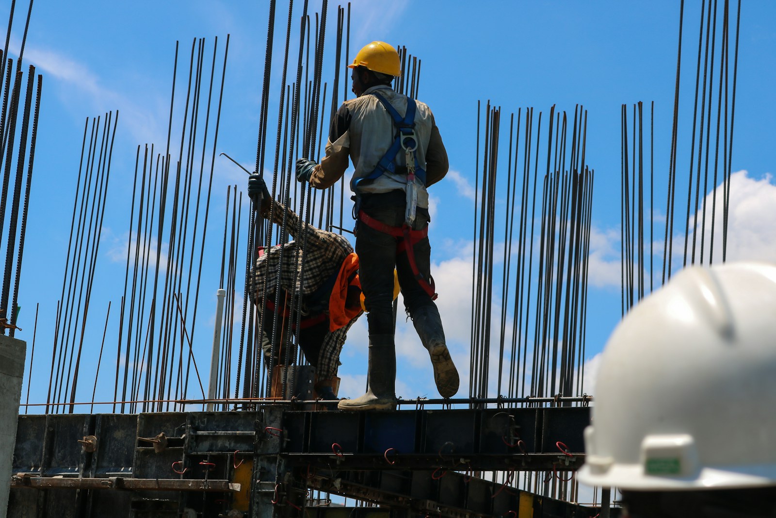 a man standing on top of a metal structure, workers' compensation